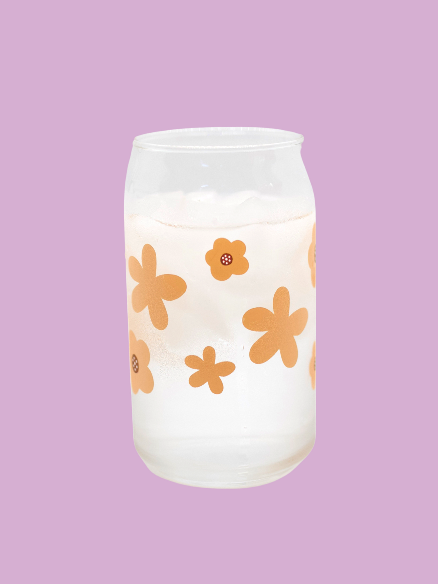 A clear can-shaped glass with a design of peach colored flowers wrapped around.