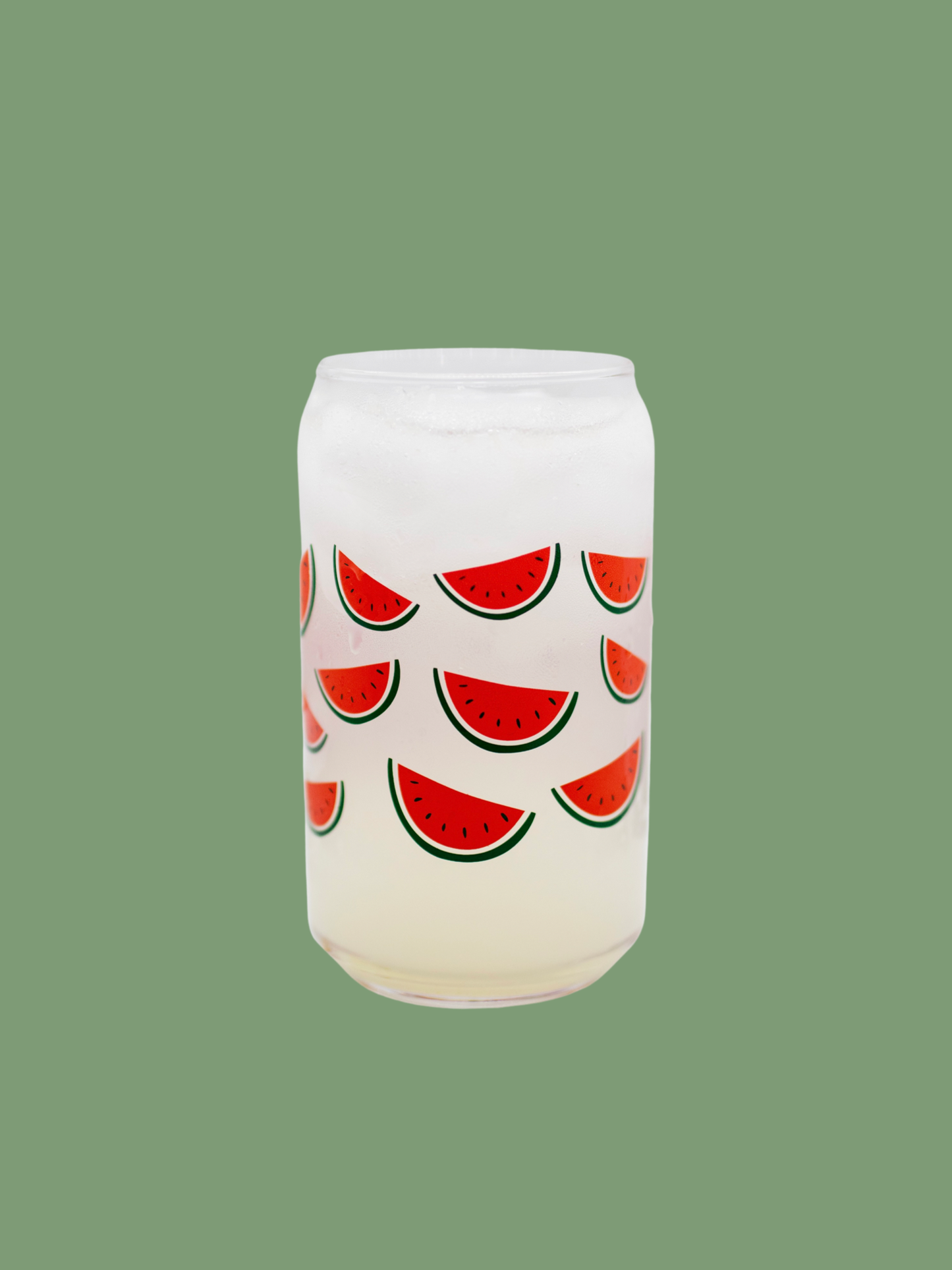 A clear can-shaped glass with watermelon design wrapped around.