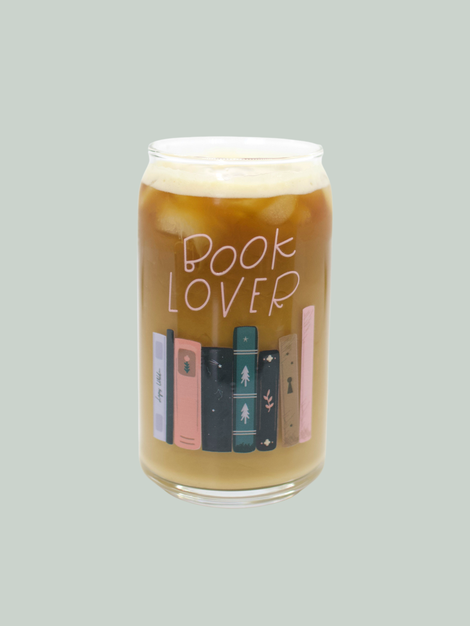 A clear glass can-shaped beverage holder with 'BOOK LOVER' text and a graphic of book spines on it.