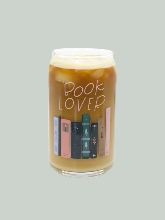 A clear glass can-shaped beverage holder with 'BOOK LOVER' text and a graphic of book spines on it.