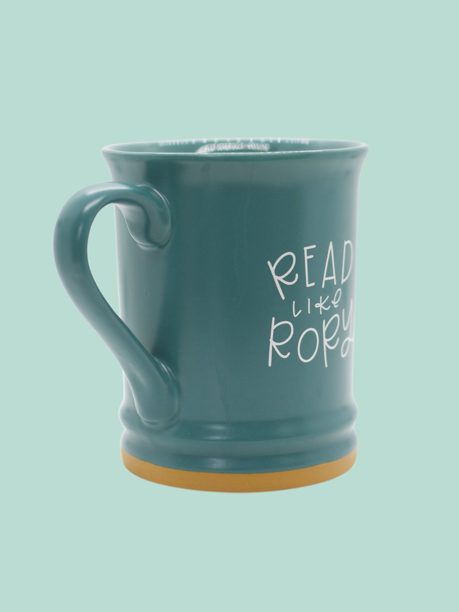 A matte teal ceramic mug with 'READ LIKE RORY' printed in white on the side.