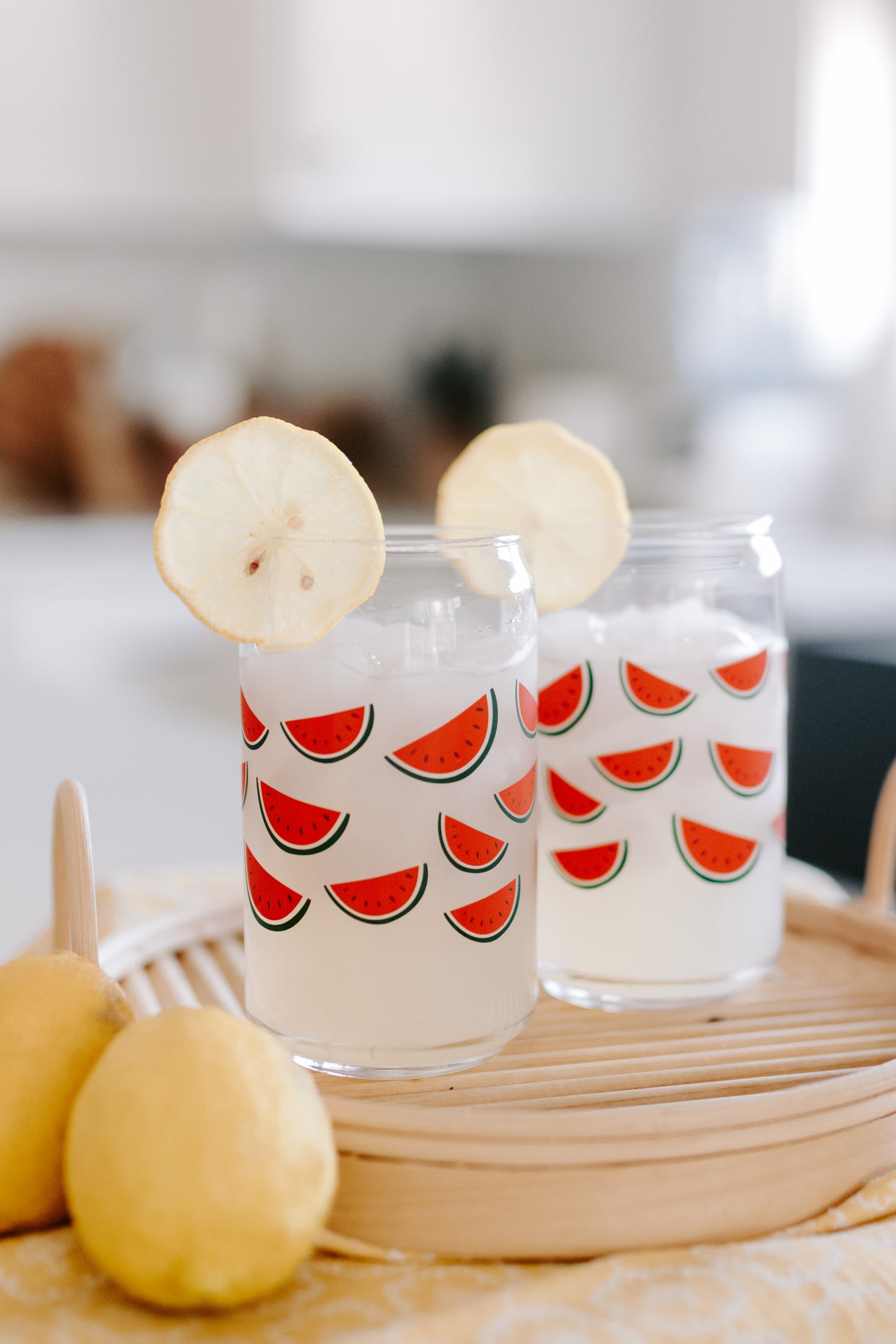 A clear can-shaped glass with watermelon design wrapped around.