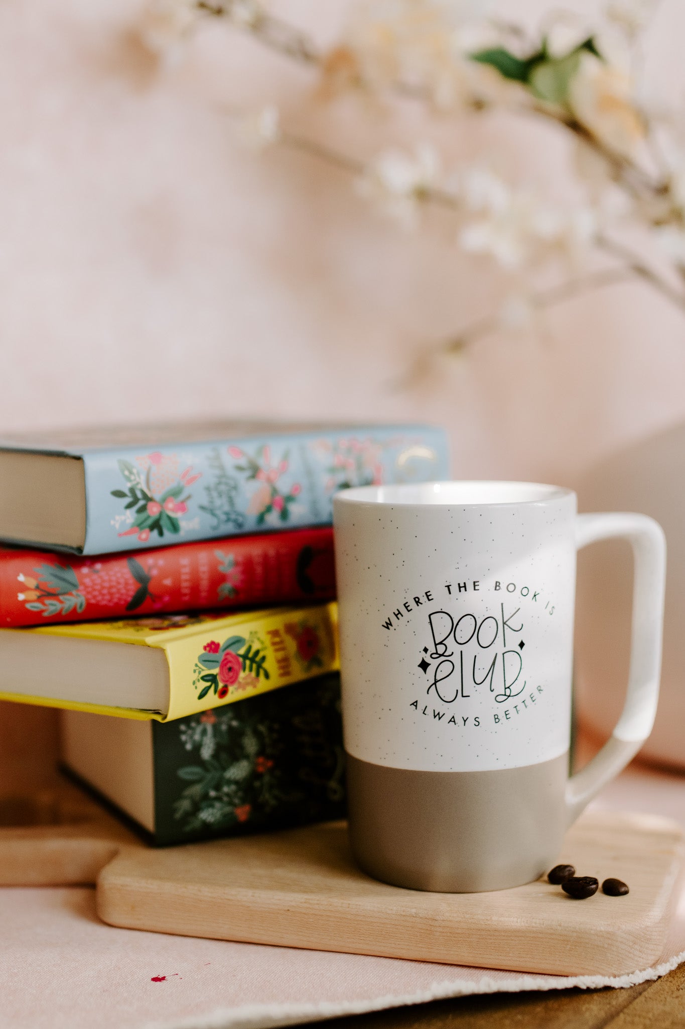 A two-tone ceramic mug with the upper part white with black speckles and the lower part taupe, featuring 'Book Club' text imprinted on the white part.