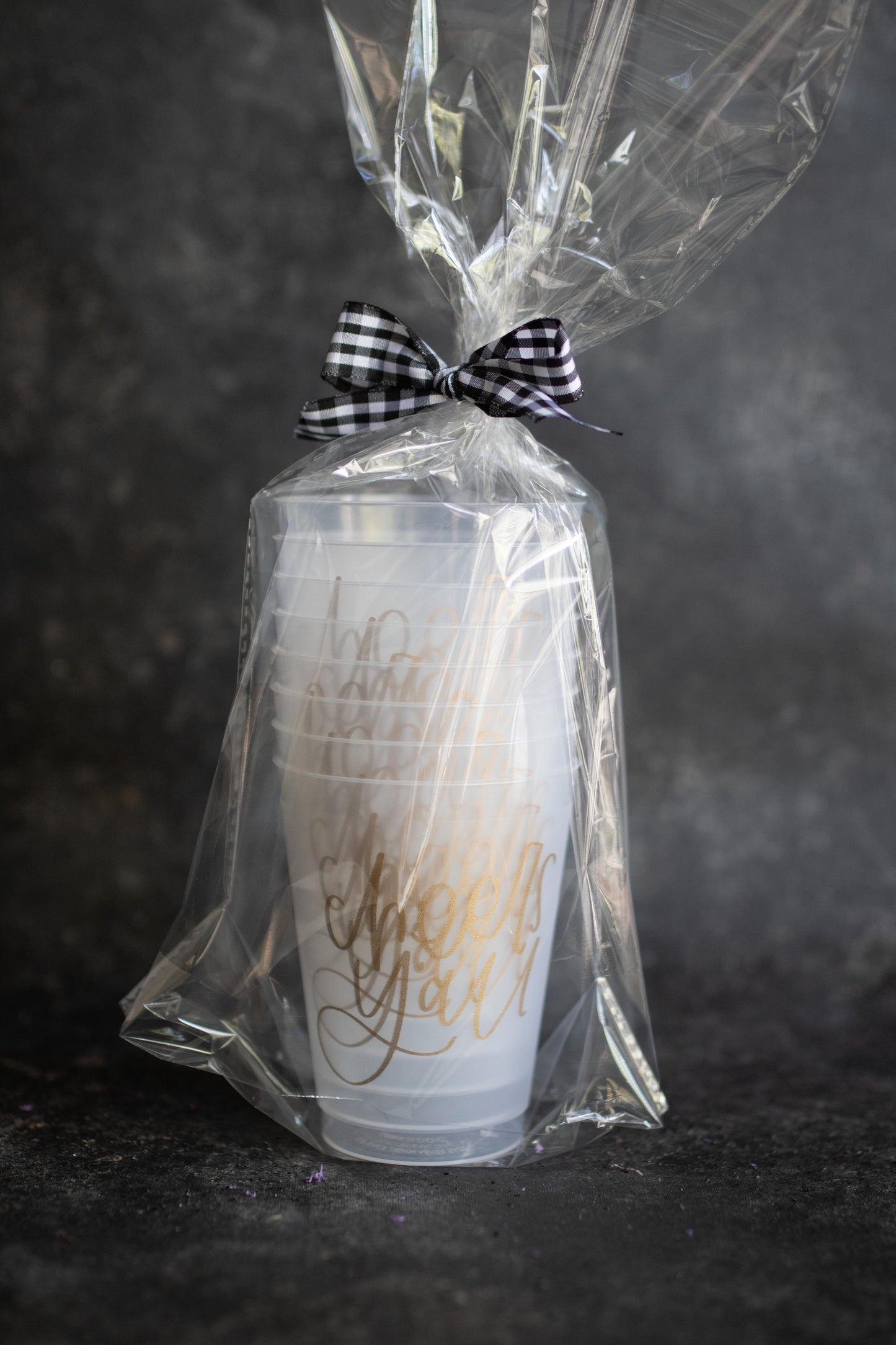 Set of 8 clear plastic stadium cups with 'Cheers Y'all' printed in gold lettering packaged inside cello bag with black gingham ribbon