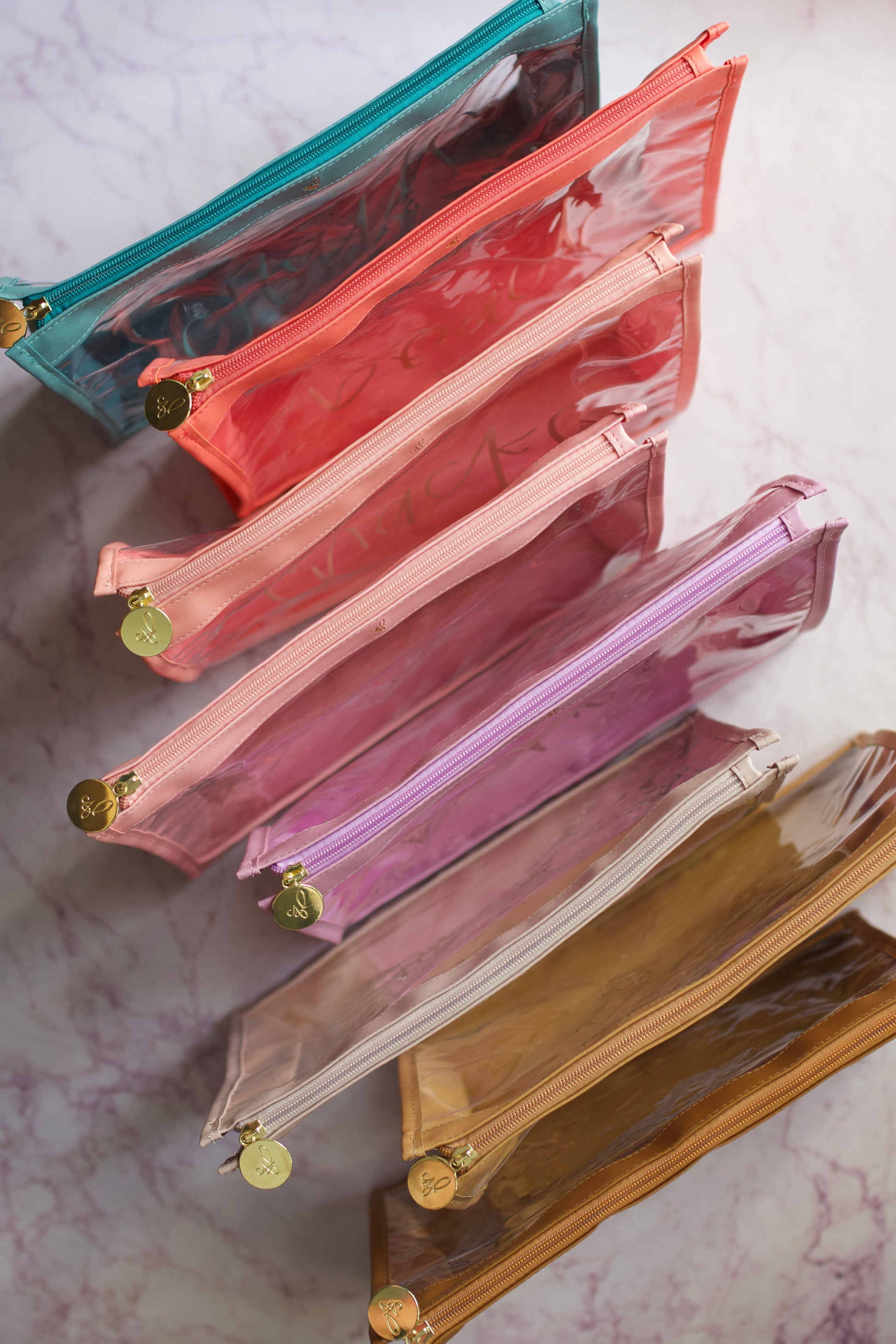 A collection of all zipper organizatioin pouches available made of faux leather in different colors and clear vinyl window to show contents inside