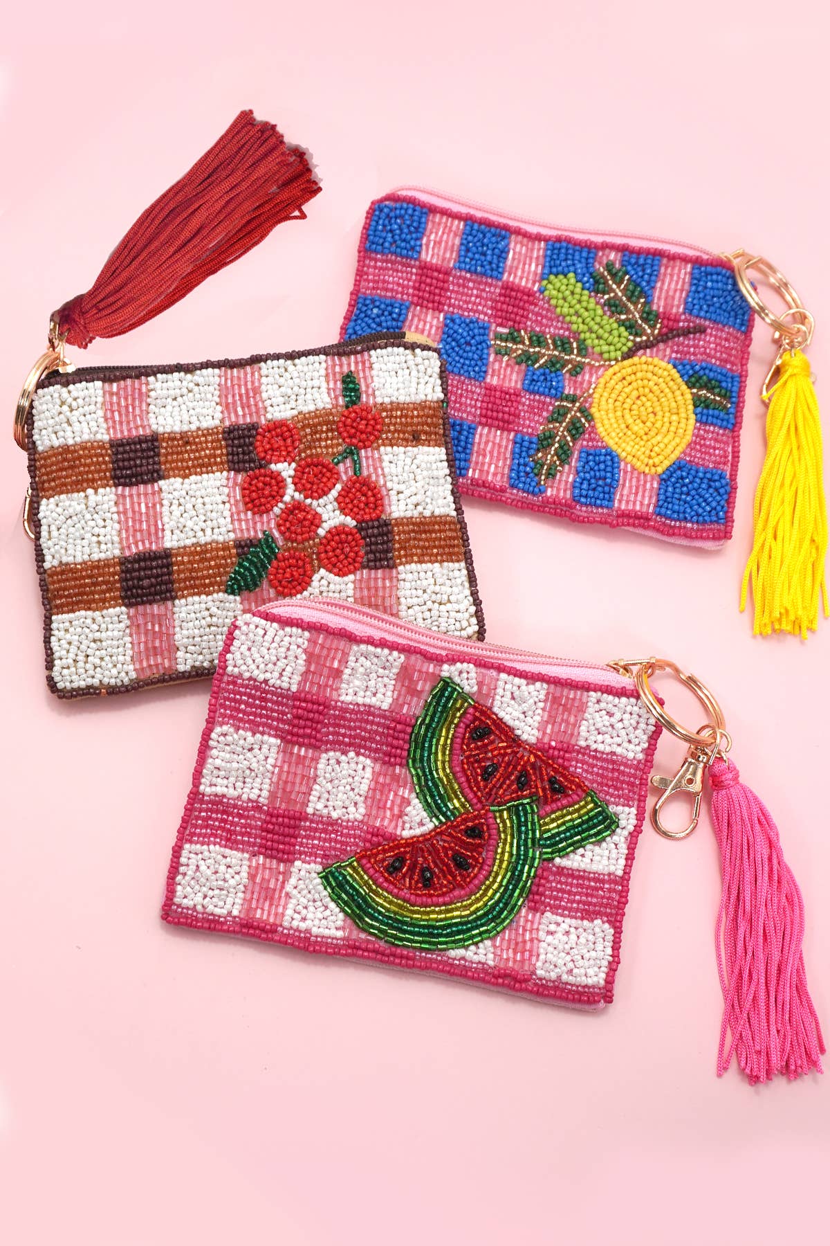A collection of three coin purses with seed bead craftsmanship, featuring a watermelon design and tassel accents, in a checkered pattern.