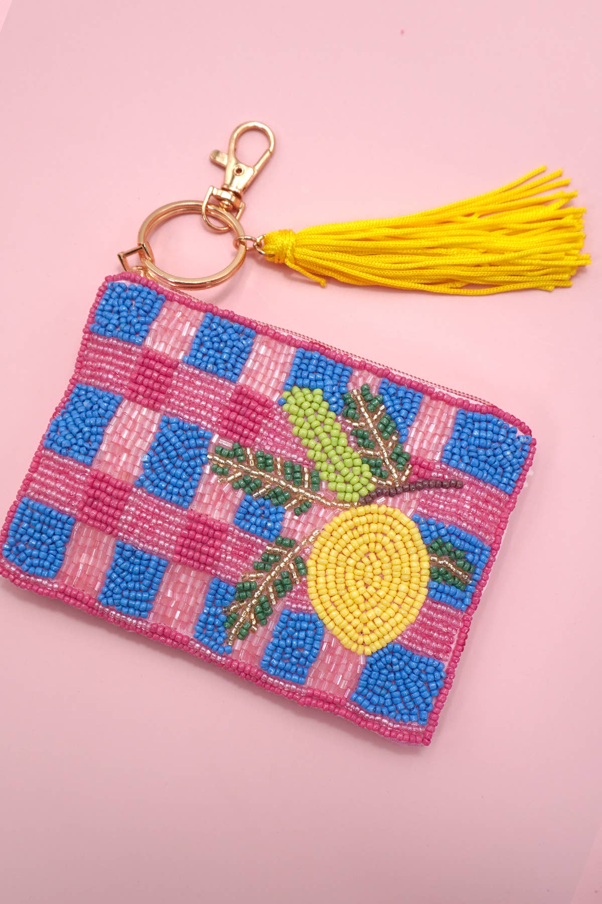 A colorful beaded coin purse with a lemon design and a tassel, featuring a checker pattern.