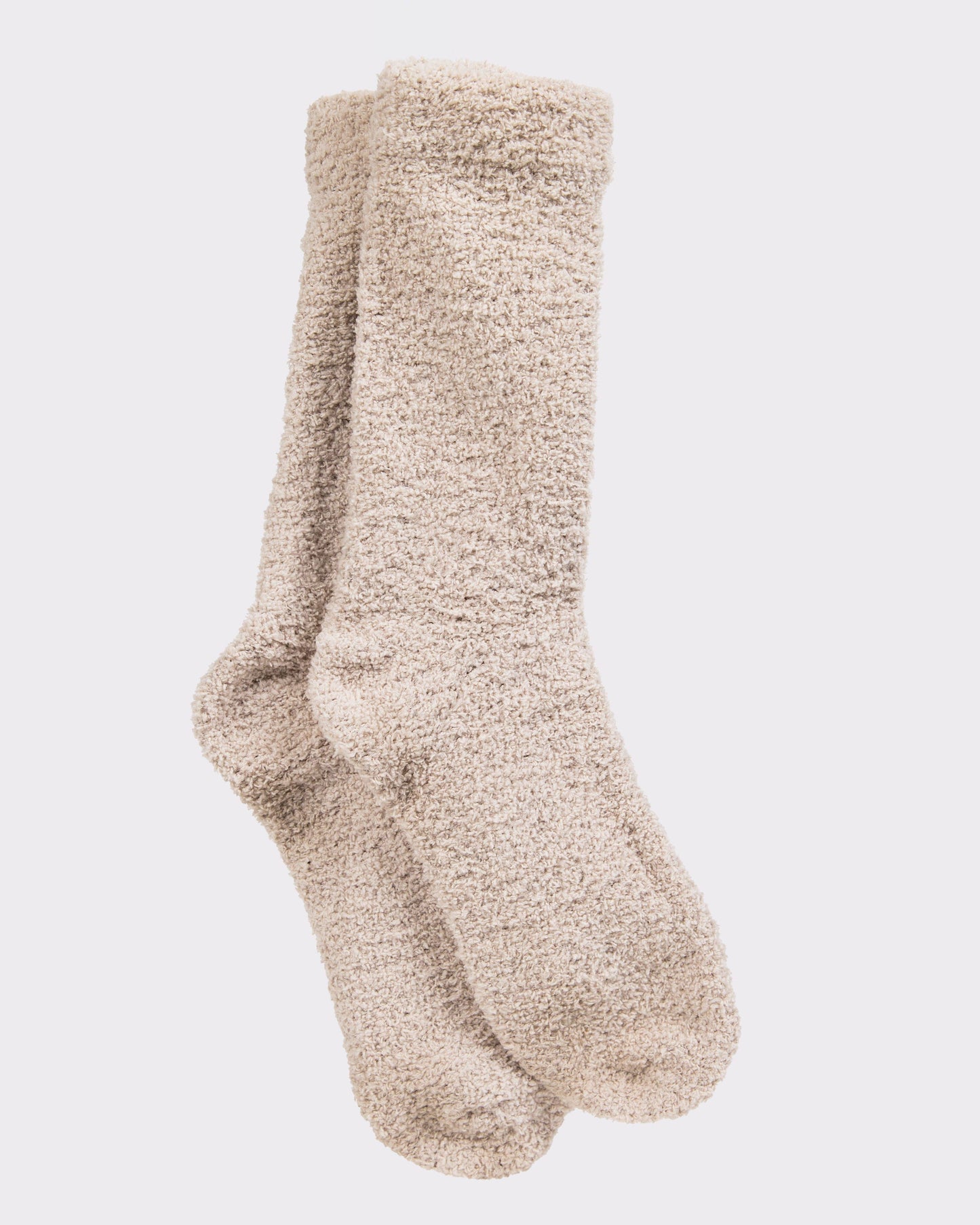 Pair of beige fuzzy socks on a light gray background