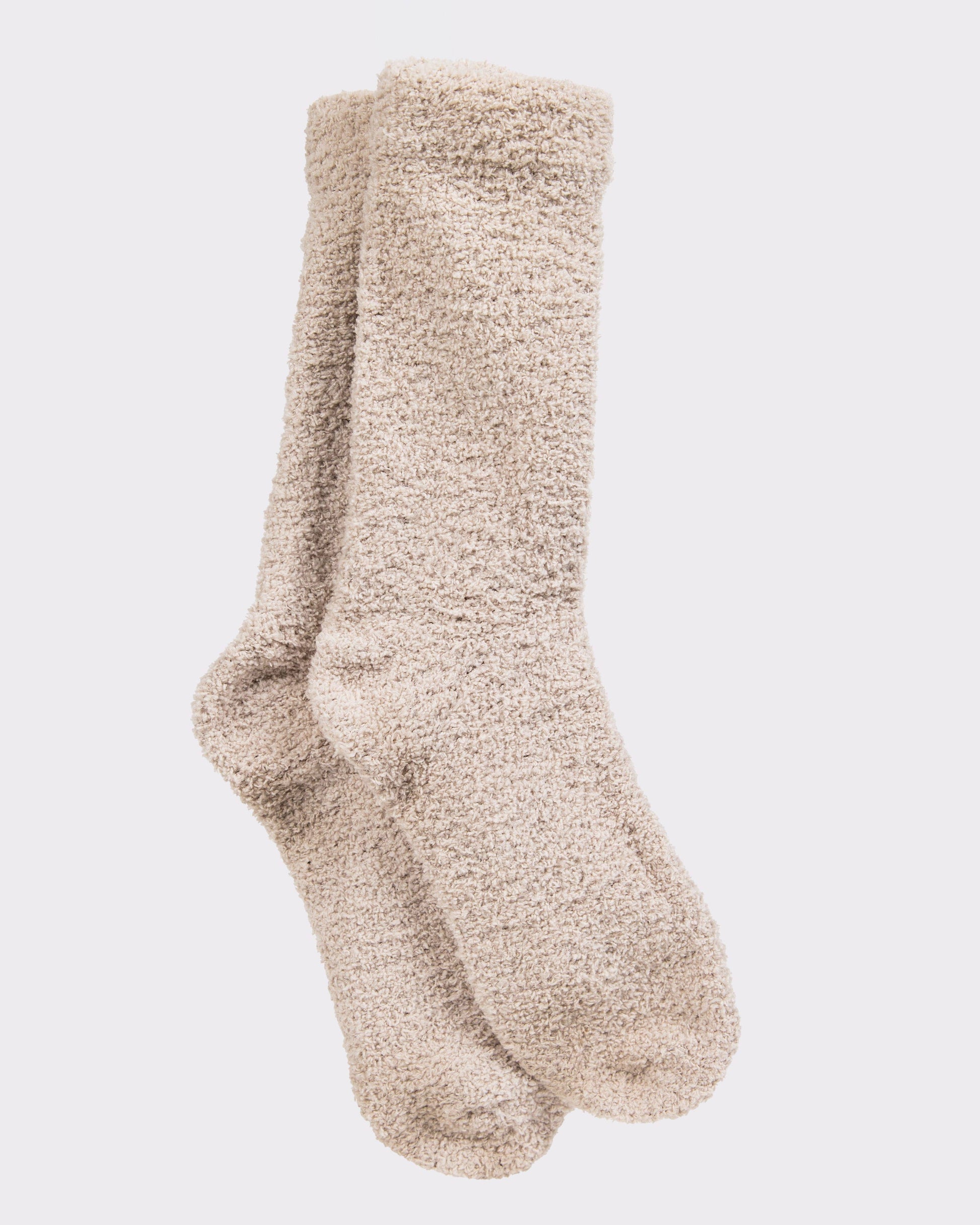 Pair of beige fuzzy socks on a light gray background