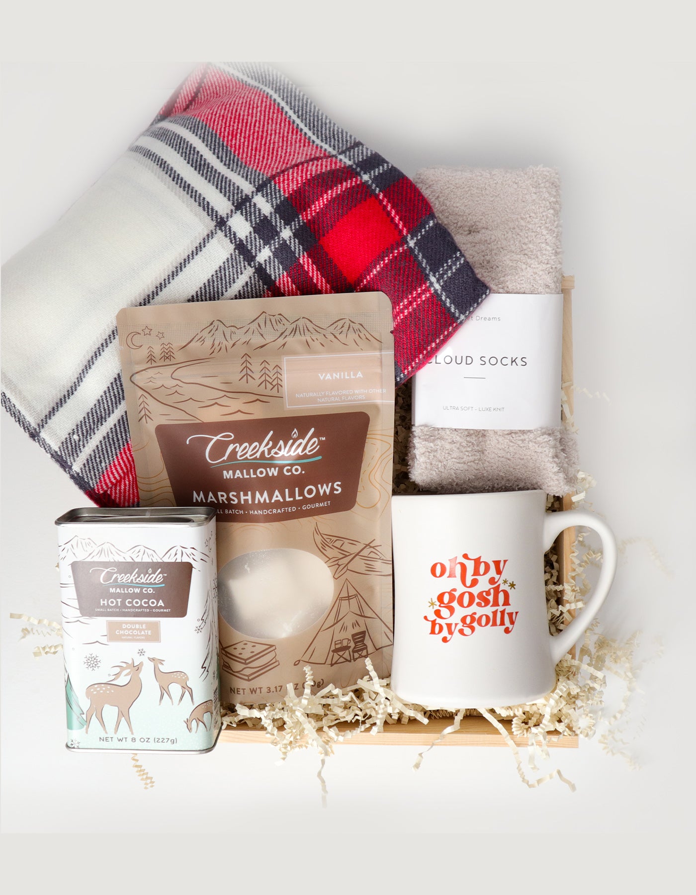 Gift set with marshmallows, hot cocoa mix, mug, and socks on a white background