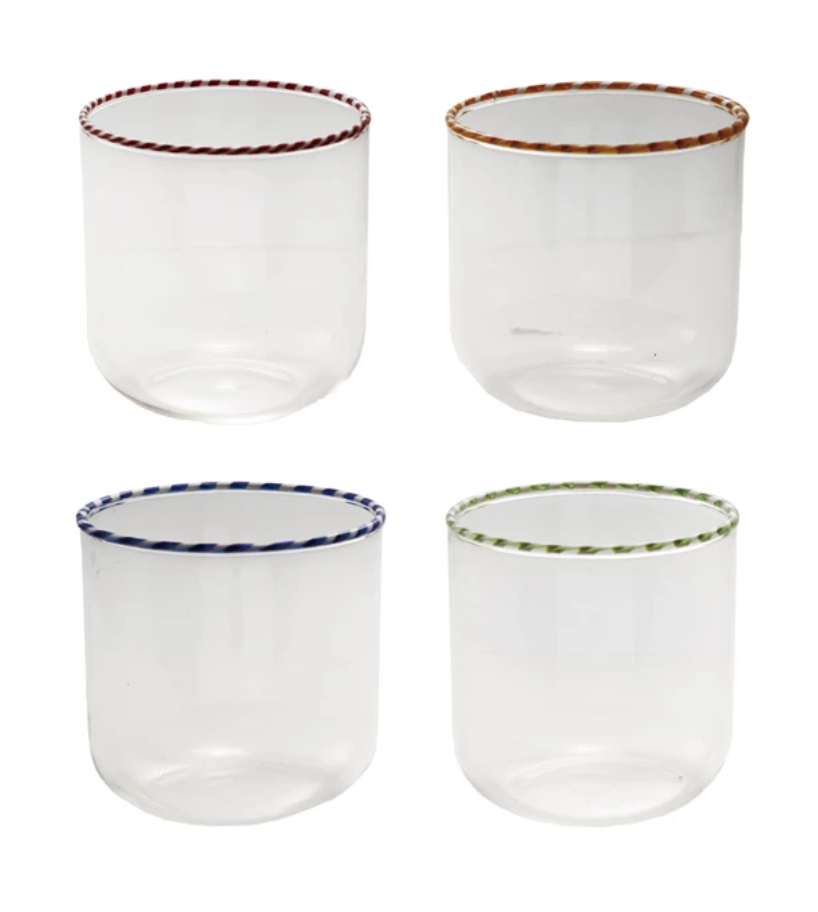 Four clear glass tumblers with colored rims on a white background