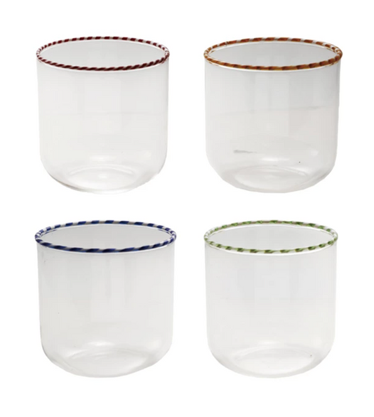 Four clear glass tumblers with colored rims on a white background