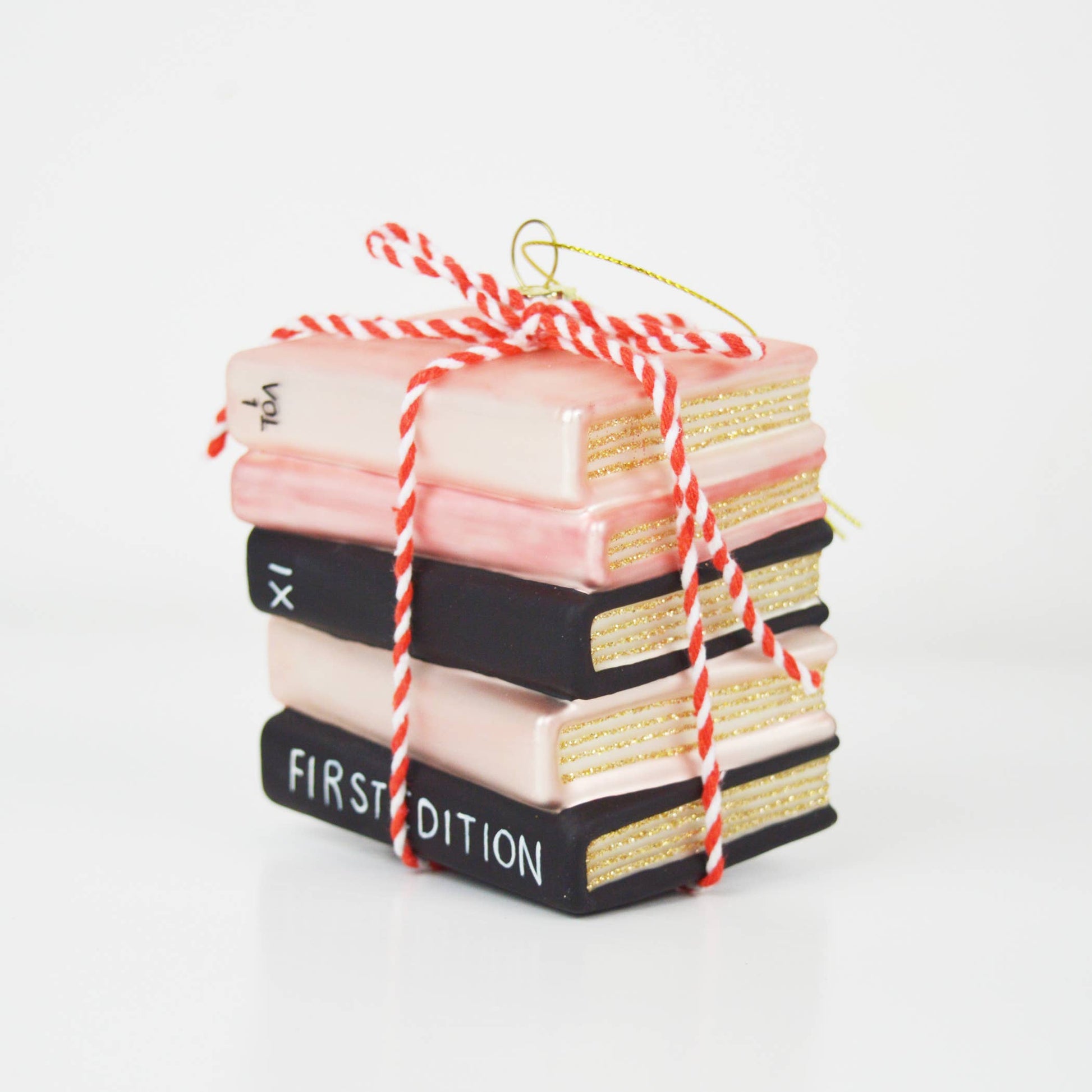 Stack of decorative books tied with red and white string on a white background