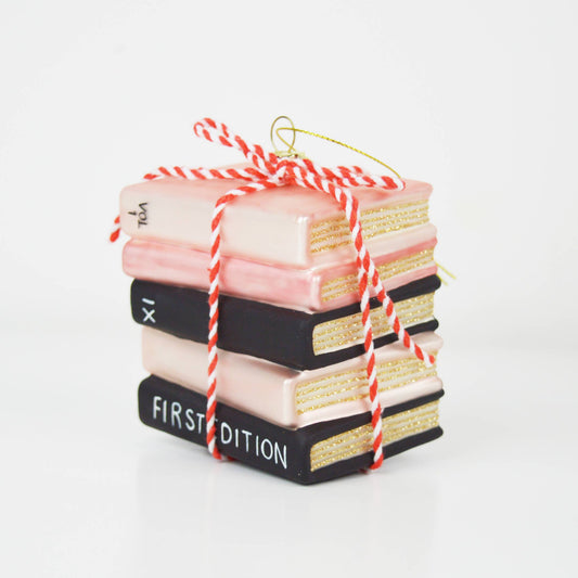 Stack of decorative books tied with red and white string on a white background